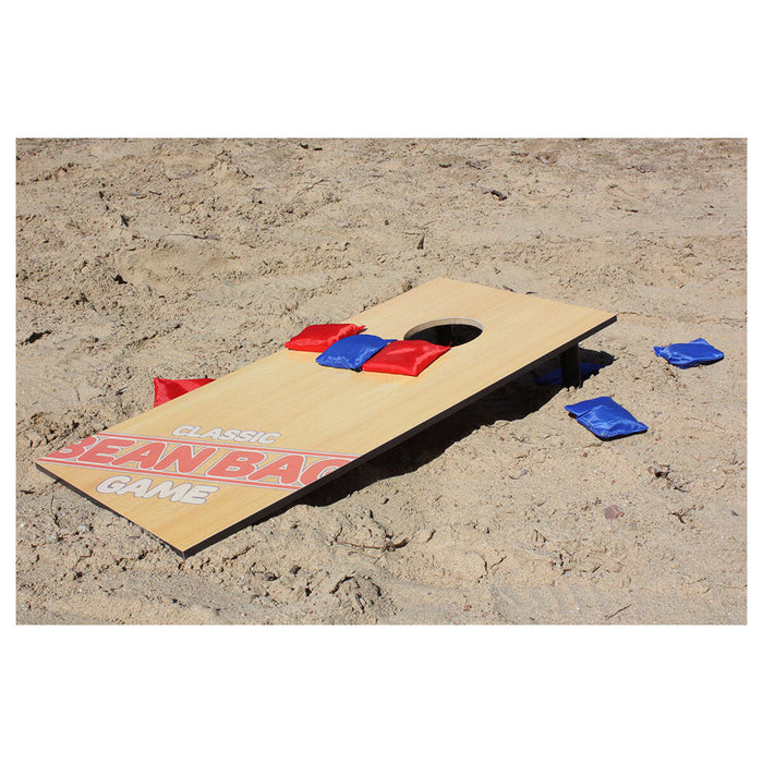 Cardboard on beach with hole cut out and red and blue bean bags 