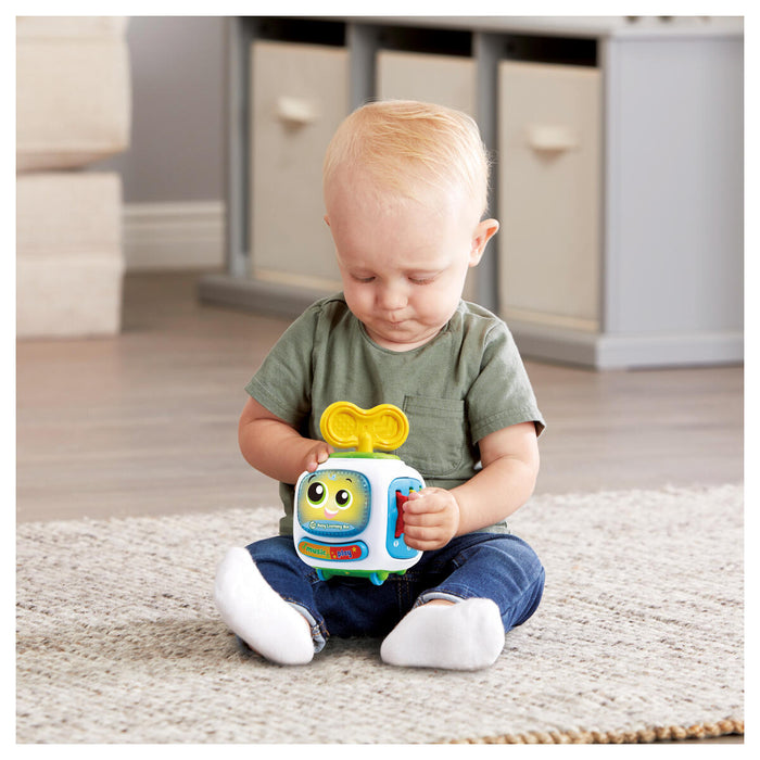 Small child sat on floor holding Learning Bot toy 