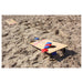 Cardboard on sand on beach with red and blue bean bags on top
